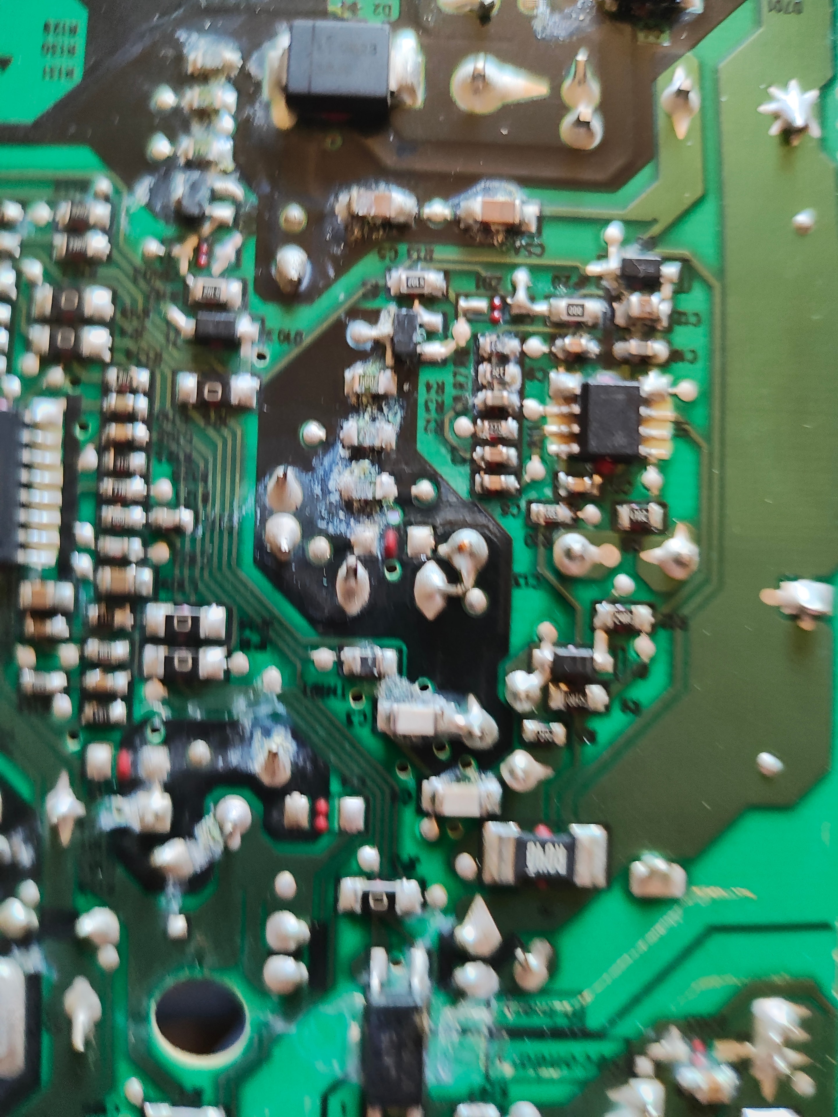 Close-up of a shorted PCB showing damaged solder joints and burnt components